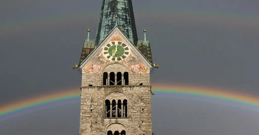 rainbow behind a church tower